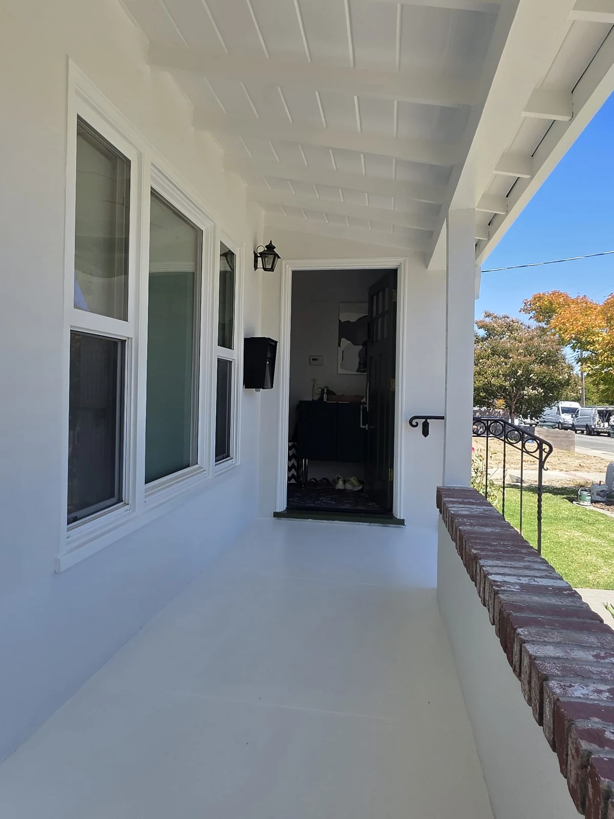 Freshly painted white front porch, ceiling, window trim and entry
